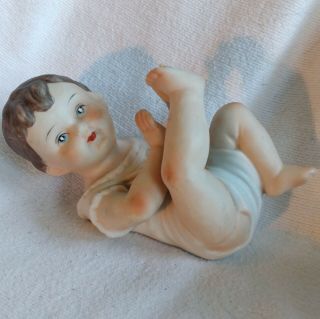Vintage Piano Baby Brunette Boy Lying On Back Feet Up Porcelain Bisque Figurine