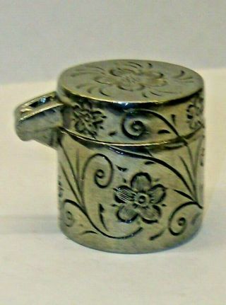 A Pewter Thimble Case With A Matching Thimble Marked On Top With A Flower