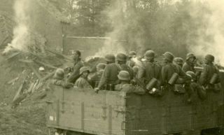 German Soldiers in truck advancing through village.  WW2 Photo 2